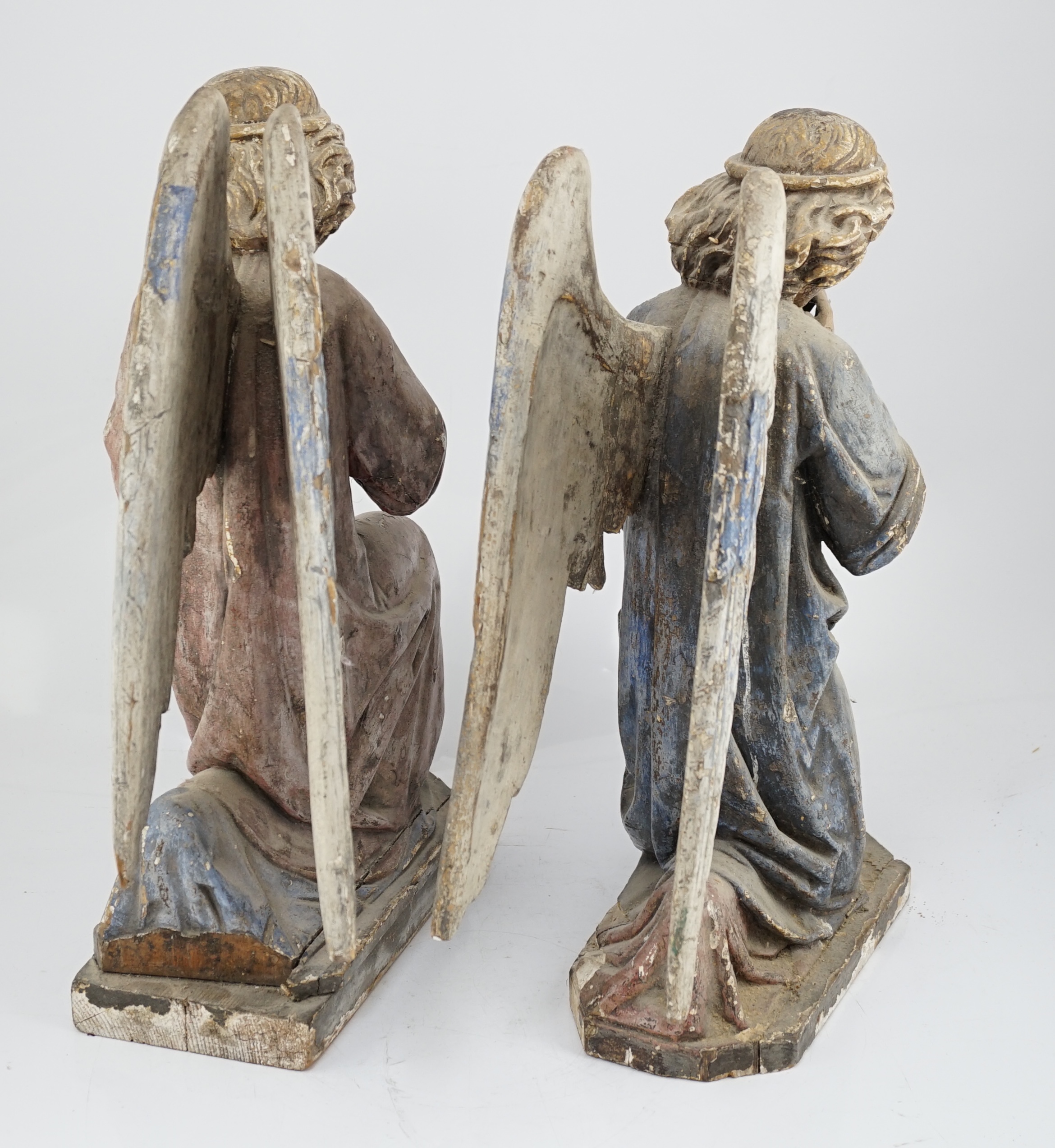 A pair of late 19th century polychrome carved painted pine praying archangels